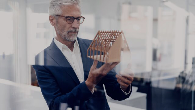 Architect looking at model house small overlay